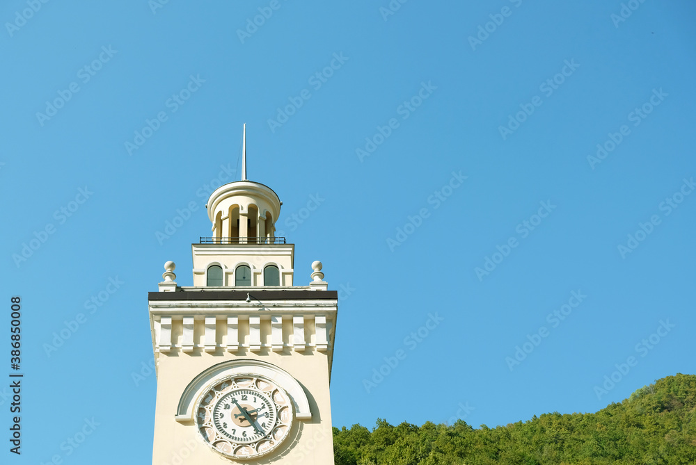 Fototapeta premium Clock tower in Rosa Khutor, Sochi, Russia. The top of the tower against a blue sky