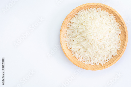 Heap of raw rice on wooden bowl 