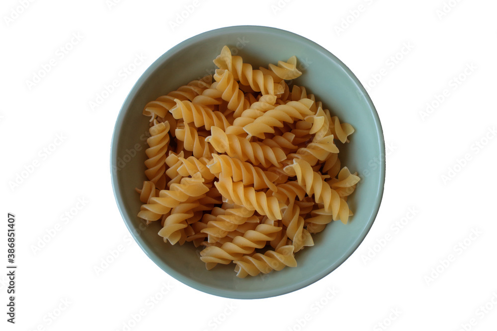 Raw fusilli pasta in a ceramic green plate on a white table. Top view. Isolated.