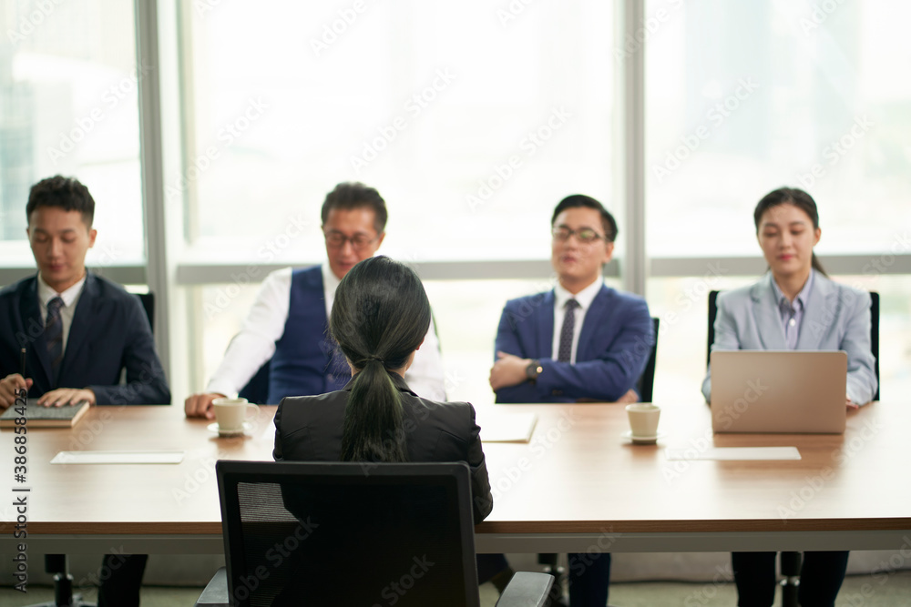 female asian candidate being interviewed by a group of business people female asian candidate being interviewed by a group of business people