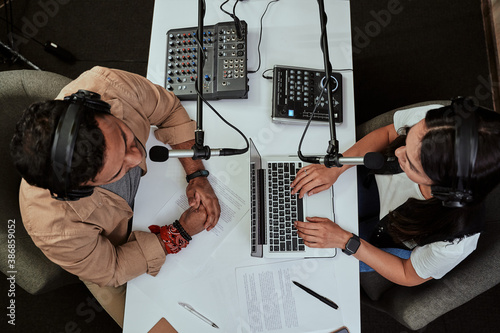 Canvas Print Top view of two radio hosts, young man and woman discussing various topics while