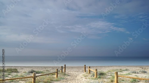 Seascape. Time lapse of clouds moving over sea and empty entrance to the sandy beach. Summer vacation. Cabo de Gata in Spain.