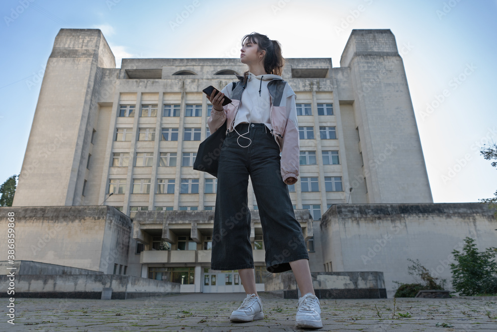 Young trendy teenage student standing in a street