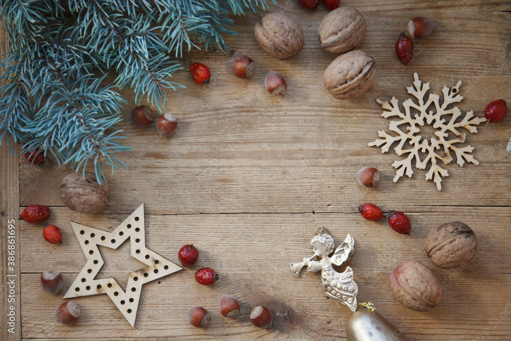 Fototapeta premium Christmas, New year card with fur tree, wooden decoration, dogrose, golden angle on wooden background