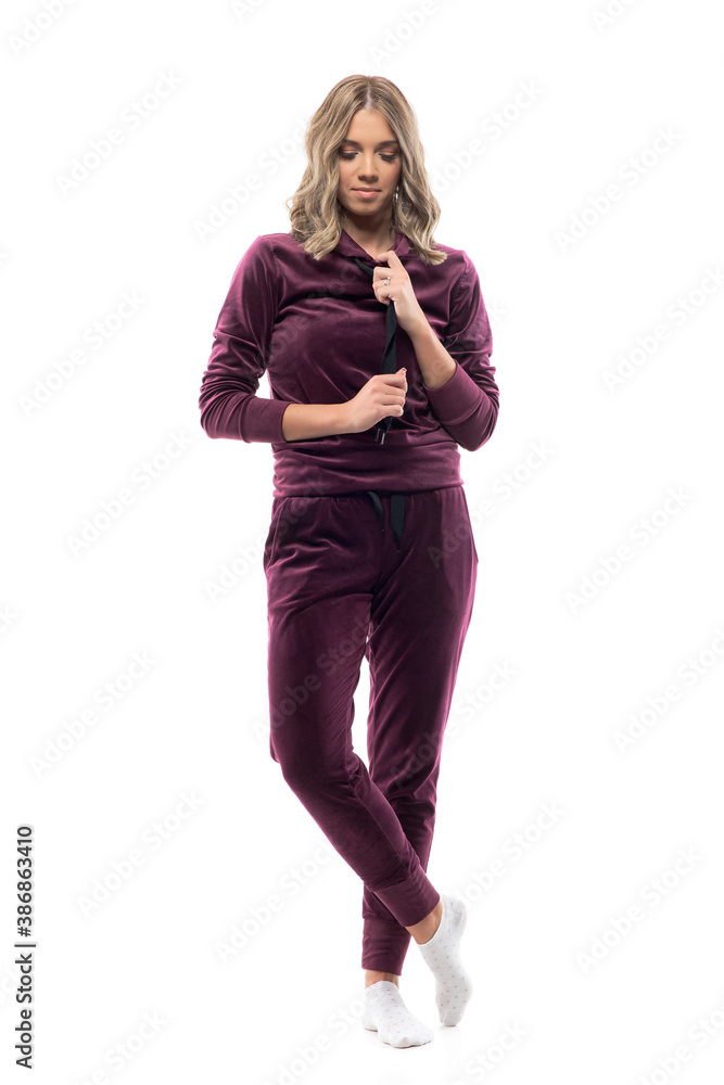 Cute feminine girl in home wear leisure clothes getting dressed and looking down. Full body isolated on white background. Cute feminine girl in home wear leisure clothes getting dressed and looking down. Full body isolated on white background.
