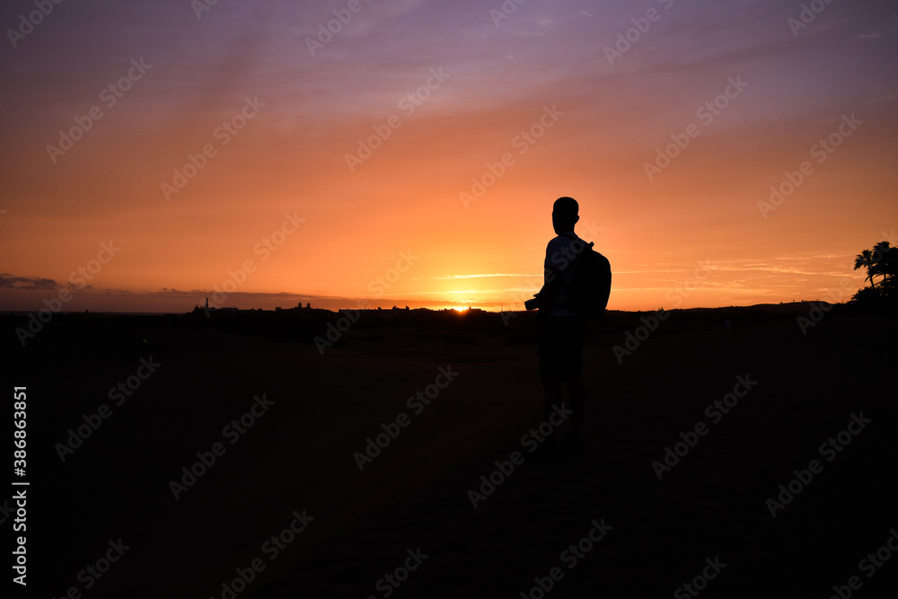 Silhouette of a man watching the sunset.
