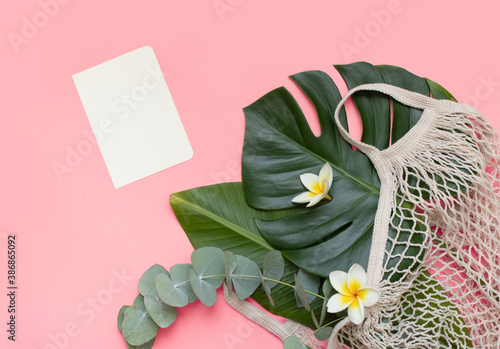 Tropical mockup, palm leaves, paper card and notebook on pink background photo