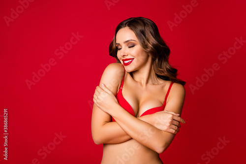 Close-up portrait of her she nice-looking attractive lovely glamorous stunning cheerful wavy-haired girl embracing herself isolated on bright vivid shine vibrant red color background