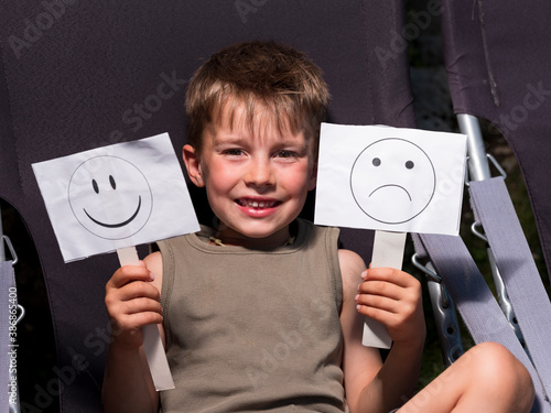 Child holds in hands placards with pictographic symbols. photo