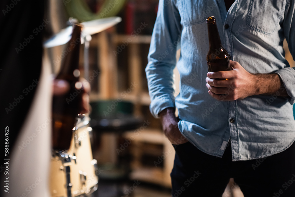 Φωτογραφία mock up a beer bottle in the hands of a musician after a rehearsal in the garage
