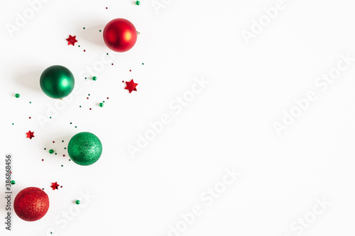 Christmas composition. Red and green decorations on white background. Christmas, winter, new year concept. Flat lay, top view, copy space