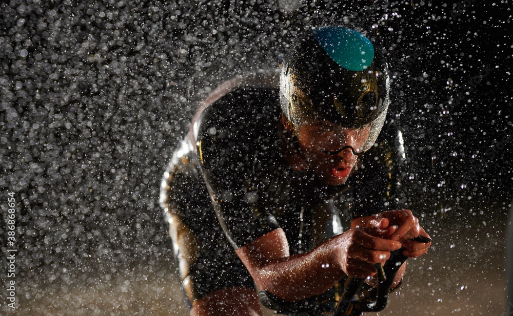 Αυτοκόλλητο triathlon athlete riding bike fast on rainy night