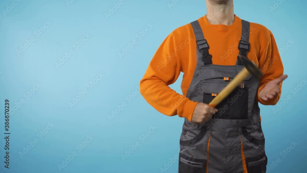 man with workwear and hammer in his hand standing on right with copy space concept man with workwear and hammer in his hand standing on right with copy space concept