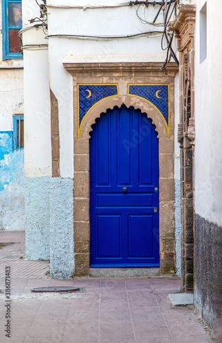 Door in the old town.raditional blue Moroccan door on typical narrow alleyway in the Medina of Essaouira, Morocco. © andibandi