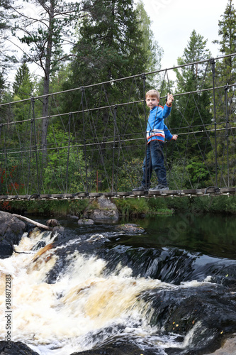 Boy on suspension bridge over Ruskeala waterfall