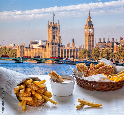 Big Ben against fish and chips served on the table in London, United Kingdom