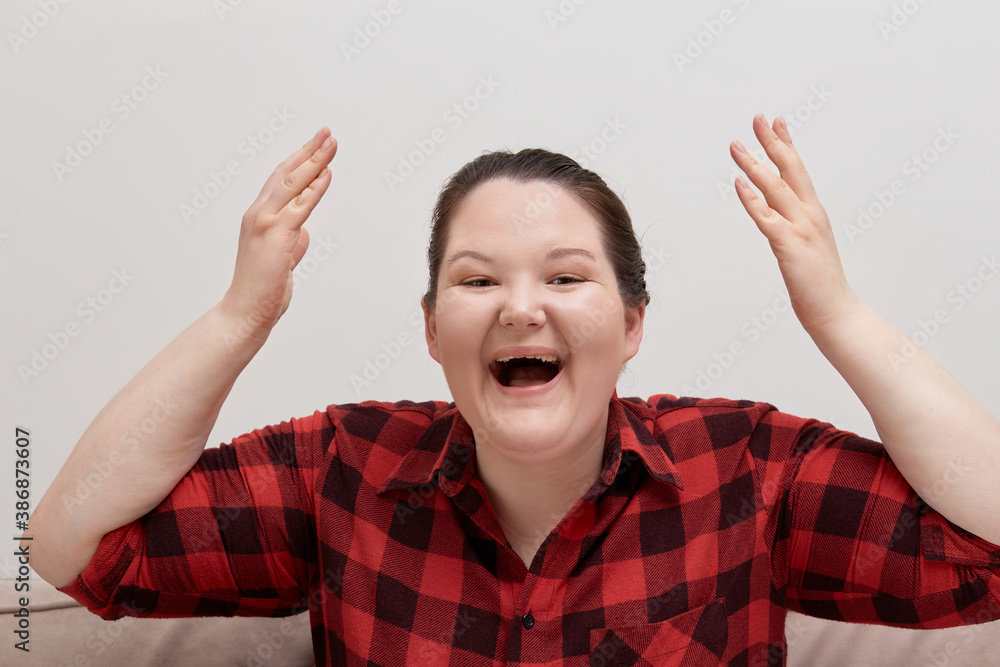 Happy smiling woman laughing and hands up in red plaid shirt. Look at the camera. Happy smiling woman laughing and hands up in red plaid shirt. Look at the camera.