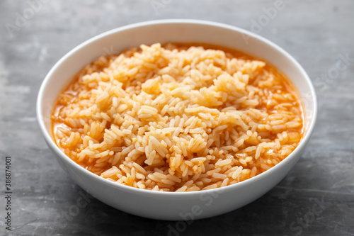 boiled rice with tomato in bowl on ceramic background