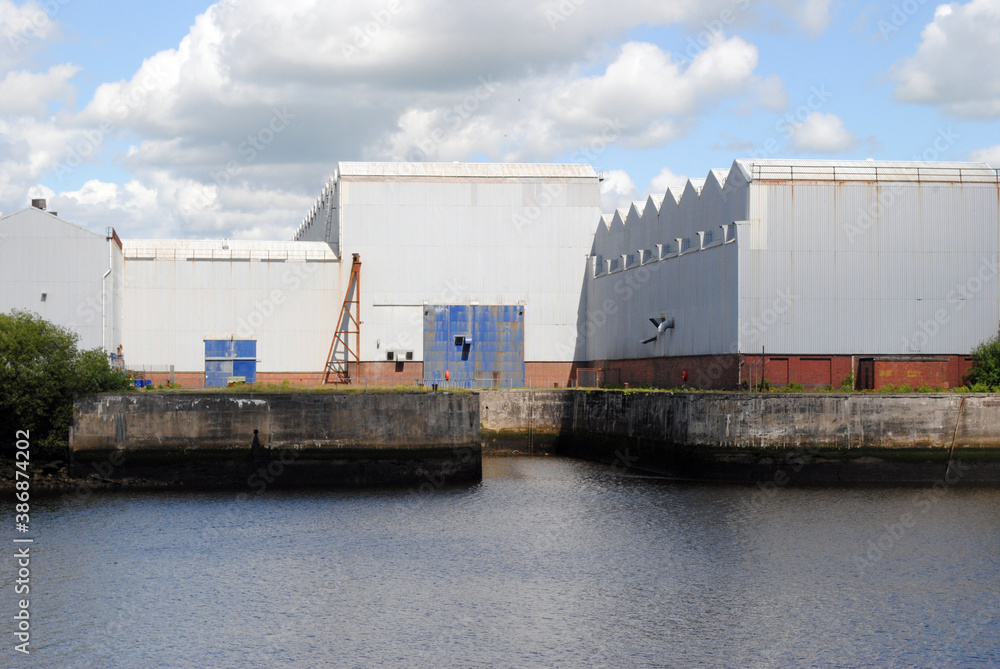 River View with Large White Industrial Buildings on Sunny Day