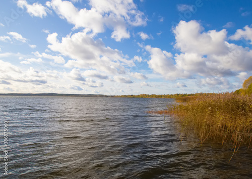 Beautiful peaceful water of Braslav lakes in an idyllic weather sunny day and dramatic blue cloudy sky.