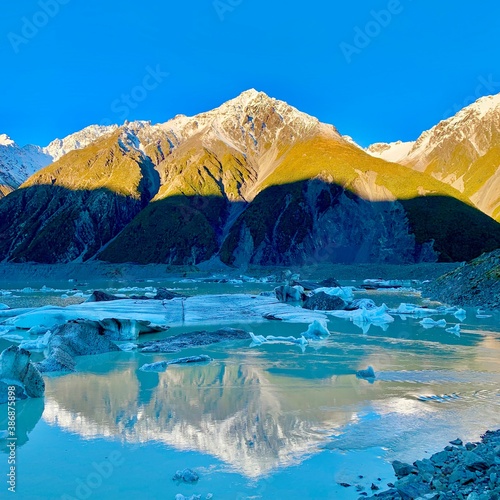 Landscape photo of Mt Cook and its reflection with icecapped mountain in different color layers in New Zealand