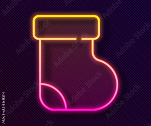 Glowing neon line Baby socks clothes icon isolated on black background. Vector.