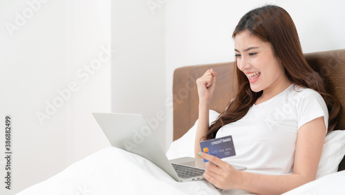 Happy asian woman doing online shopping at home  Women shopping online with credit card and laptop on the bed at home 