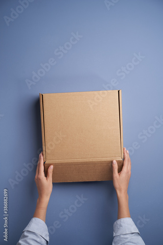 Woman hands open empty cardboard box, top view