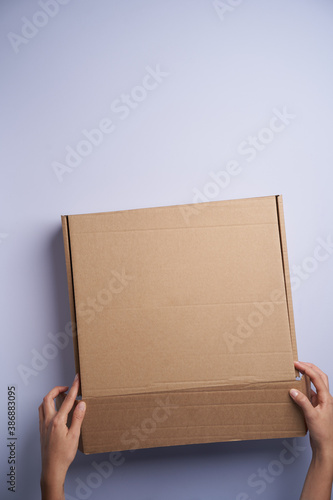 Woman hands open empty cardboard box, top view © Gecko Studio