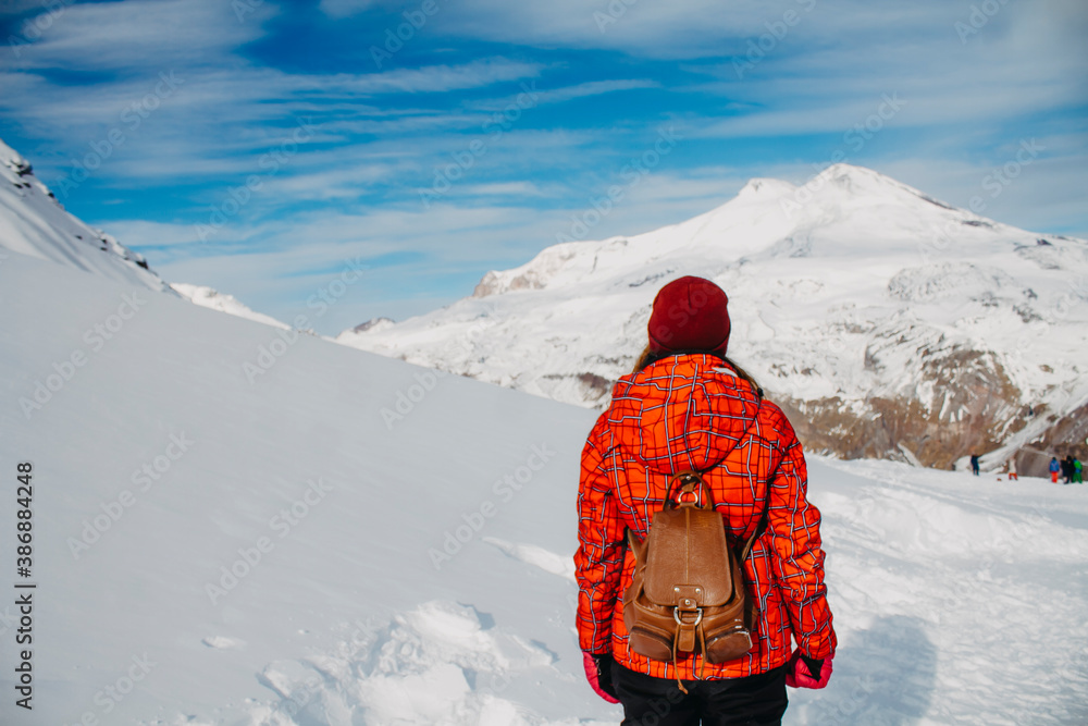 A young woman looks at Mount Elbrus. View of Elbrus. Mountain Cheget.