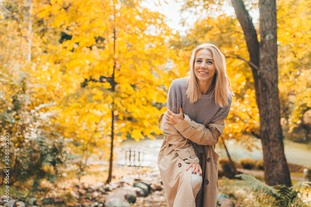 Young woman in yellow autumn park or forest with yellow leaves look at camera. Young woman in yellow autumn park or forest with yellow leaves look at camera.