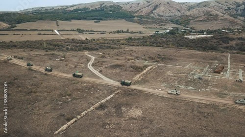 Military convoy moves frame with aerial