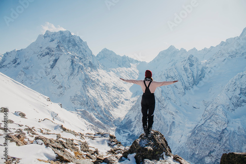 Winter holidays in the mountains. Young woman on a background of snowy mountains.