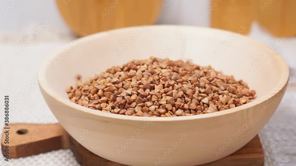raw buckwheat grain on a wooden spoon on wood table background. selective focus raw buckwheat grain on a wooden spoon on wood table background. selective focus