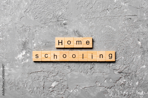 Home schooling word written on wood block. Home schooling text on table, concept