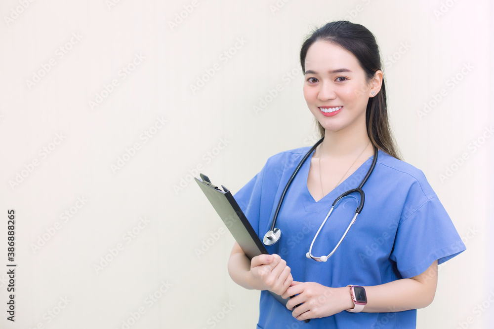 Asian woman with long hair in medical clothing holds a clipboard in her hand and has stethoscope on neck with white background. Asian woman with long hair in medical clothing holds a clipboard in her hand and has stethoscope on neck with white background.