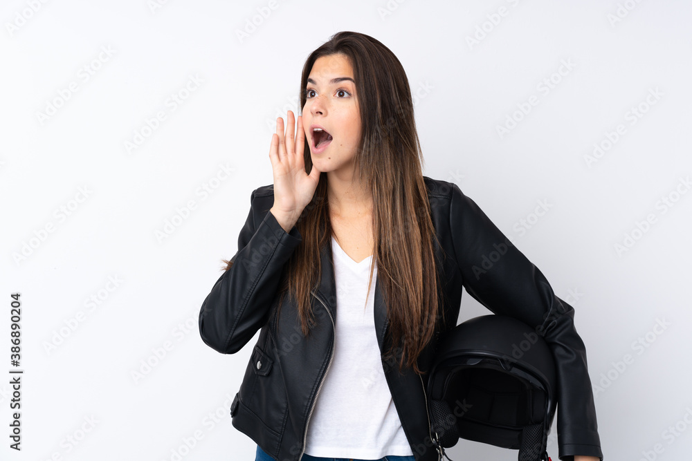 Young woman with a motorcycle helmet over isolated white background shouting with mouth wide open Young woman with a motorcycle helmet over isolated white background shouting with mouth wide open