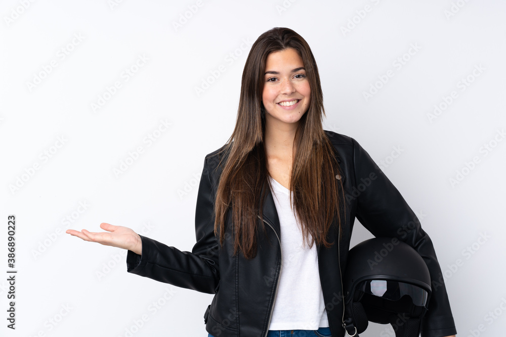 Young woman with a motorcycle helmet over isolated white background holding copyspace imaginary on the palm Young woman with a motorcycle helmet over isolated white background holding copyspace imaginary on the palm
