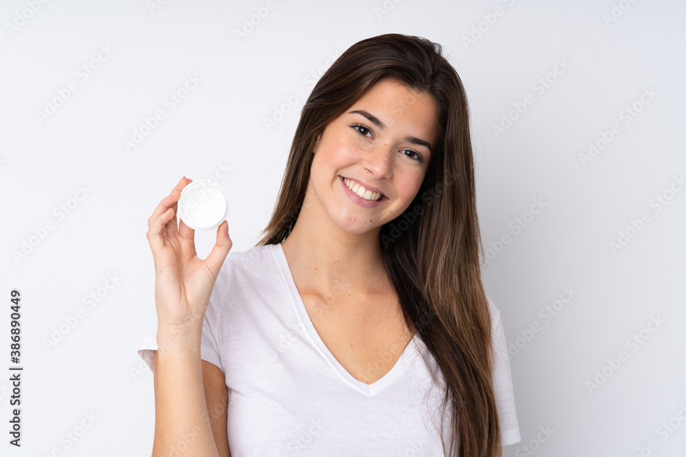 Teenager girl over isolated background with moisturizer and happiness Teenager girl over isolated background with moisturizer and happiness