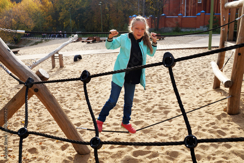 little girl climbing rope ladder on the playground