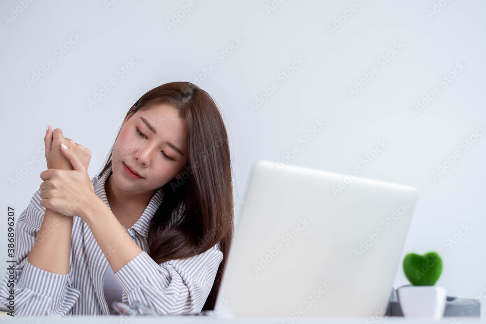 Concept Office Syndrome, young Asian female office worker tired from hard work, wrist pain due to working hours consecutively. Concept Office Syndrome, young Asian female office worker tired from hard work, wrist pain due to working hours consecutively.