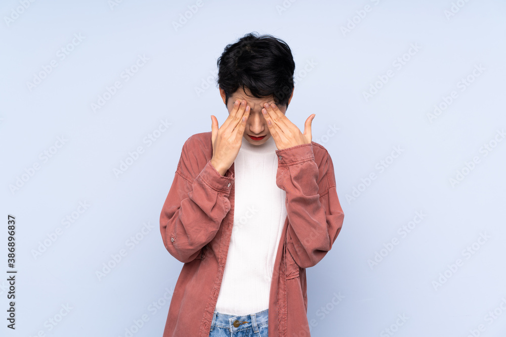 Young Asian girl over isolated blue background with tired and sick expression Young Asian girl over isolated blue background with tired and sick expression