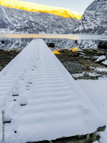 Snow-covered jetty winter landscape at the fjord lake Norway. photo