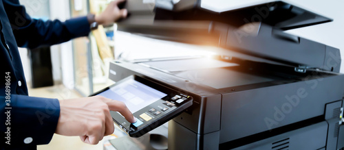 Obraz na plátně Bussiness man Hand press button on panel of printer, printer scanner laser office copy machine supplies start concept