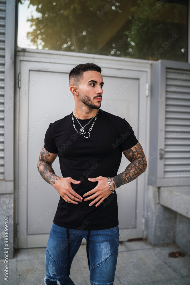 Chico joven tatuado posando de manera natural Chico joven tatuado posando de manera natural