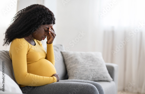 Foto Young pregnant black woman suffering from headache or migraine