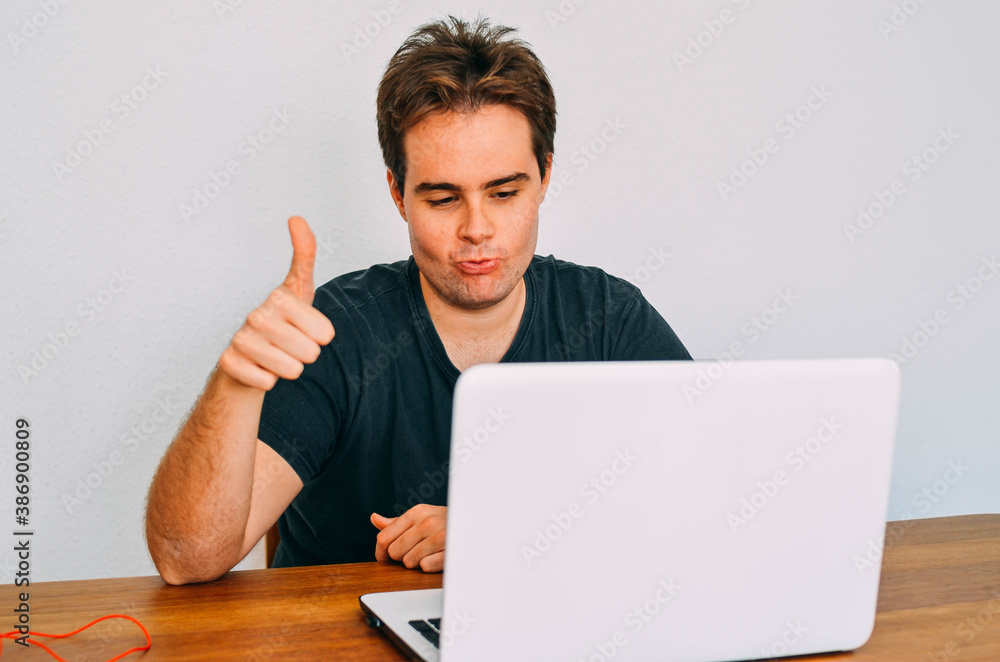 Young Flabby Redhead Nerd Saying Okey to his Laptop Screen in Video Call Young Flabby Redhead Nerd Saying Okey to his Laptop Screen in Video Call