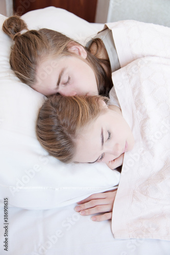 Young loving caucasian couple man and woman sleeping in bed in bedroom