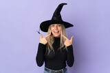 Young woman with witch costume over isolated background giving a thumbs up gesture