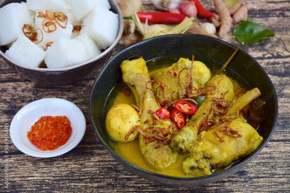 Opor ayam, chicken cooked in coconut milk from Indonesia, from Central Java, added with boiled eggs, served with lontong and sambal. Popular dish for lebaran or Eid al-Fitr Opor ayam, chicken cooked in coconut milk from Indonesia, from Central Java, added with boiled eggs, served with lontong and sambal. Popular dish for lebaran or Eid al-Fitr